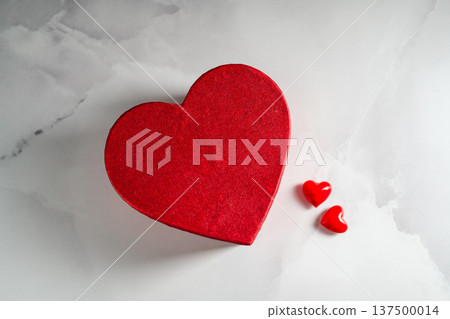 Valentine's Day background. Red heart gift box and two small hearts over bright marble background, copy space. 137500014