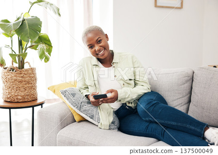 Portrait, woman and typing with phone on sofa for social media, chat and online notification at home. Happy african person relax with smartphone, download mobile games or scroll on digital multimedia Portrait, woman and typing with phone on sofa for social media, chat and online notification at home. Happy african person relax with smartphone, download mobile games or scroll on digital multimedia 137500049