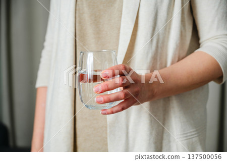 Woman holding a glass of clear water. Healthy lifestyle, beauty skin health care concept Woman holding a glass of clear water. Healthy lifestyle, beauty skin health care concept 137500056