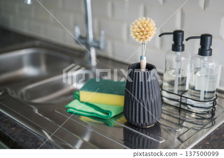 . Wooden brush for washing dishes in the kitchen next to sink. Eco friendly, zero waste or conscious consumption concept. Copy space . Wooden brush for washing dishes in the kitchen next to sink. Eco friendly, zero waste or conscious consumption concept. Copy space 137500099