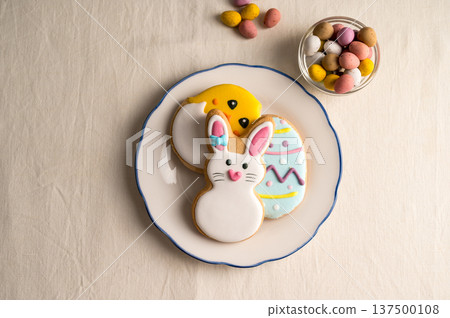 Easter festive background. Colourful easter cookies bunny, egg and chick in a plate with eggs candies 137500108