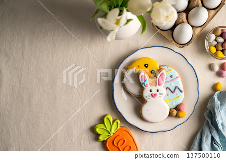 Easter festive background. Colourful easter cookies bunny, egg, chick and carrot. White spring tulips bouquet. Easter festive background. Colourful easter cookies bunny, egg, chick and carrot. White spring tulips bouquet. 137500110