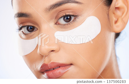 Portrait, skincare and woman with eye patch for anti aging or skin glow for beauty on studio background. Cosmetics, facial detox and face of model with pads or collagen mask for dermatology product. Portrait, skincare and woman with eye patch for anti aging or skin glow for beauty on studio background. Cosmetics, facial detox and face of model with pads or collagen mask for dermatology product. 137500283