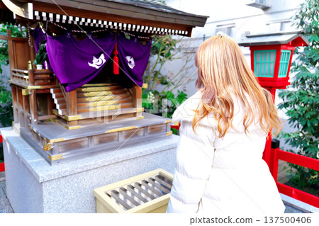 A woman praying at a shrine. 137500406