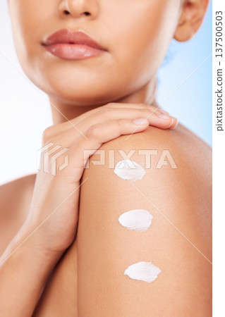 Closeup, shoulder and woman with cream, dermatology or wellness on a blue studio background. Zoom, person or model with beauty, creme or lotion with shine, product or glow with aesthetic or cosmetics Closeup, shoulder and woman with cream, dermatology or wellness on a blue studio background. Zoom, person or model with beauty, creme or lotion with shine, product or glow with aesthetic or cosmetics 137500503