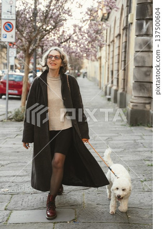 Woman Walking Dog on a Flowering Street Woman Walking Dog on a Flowering Street 137500604