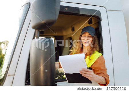 Portrait of beautiful young woman professional truck driver checking shipment list on a -parking lot 137500618