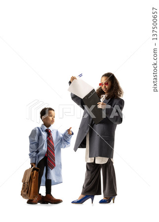 Children dressed as business professionals interacting with documents and briefcase, symbolizing ambition and future careers. Children dressed as business professionals interacting with documents and briefcase, symbolizing ambition and future careers. 137500657