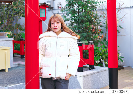 一位女模特兒站在城市中類似寺廟的地方。這是一張冬季肖像照,畫面中她穿著白色羽絨服,背景則是一座朱紅色的鳥居。 一位女模特兒站在城市中類似寺廟的地方。這是一張冬季肖像照,畫面中她穿著白色羽絨服,背景則是一座朱紅色的鳥居。 137500673