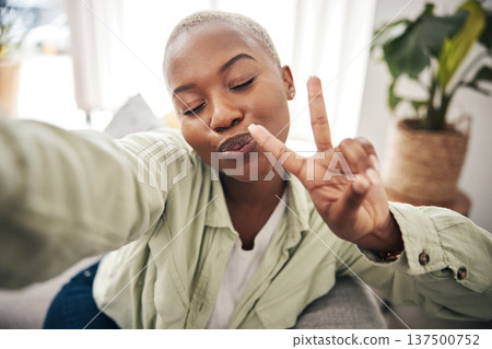 Woman, face and peace for selfie in home while live streaming vlog, post update or broadcast. Happy african content creator, profile picture or show v sign with hand emoji for social media influencer Woman, face and peace for selfie in home while live streaming vlog, post update or broadcast. Happy african content creator, profile picture or show v sign with hand emoji for social media influencer 137500752
