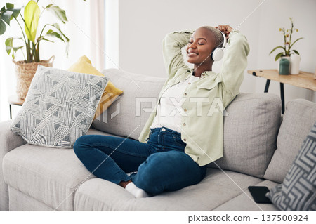 Black woman, meditation and listening to podcast to relax with headphones in home, living room or peace on sofa. Music, tech or happiness on face of person with calm, mindset or wellness in apartment 137500924