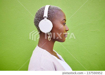 Music headphones, profile and black woman listening on green wall background mockup space. Radio, serious and African person streaming podcast, hearing audio and sound of jazz media on technology. Music headphones, profile and black woman listening on green wall background mockup space. Radio, serious and African person streaming podcast, hearing audio and sound of jazz media on technology. 137500952