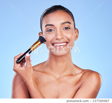 Happy woman, portrait and brush in beauty, makeup or cosmetics against a blue studio background. Female person or model smile applying skincare product in happiness for foundation or facial treatment 137500987