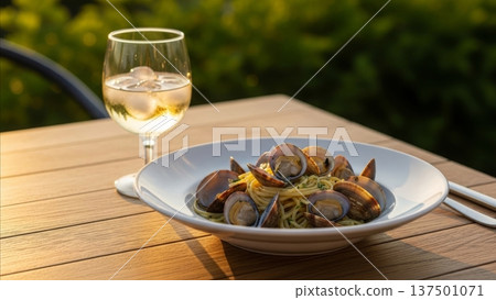 Fresh clams pasta linguine with white wine glass outdoor dining on wooden deck table restaurant setting 137501071