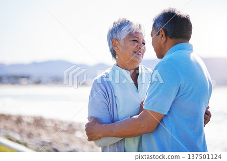 Happy, love and senior couple at a beach with conversation, romance and bond with a smile on relax holiday. Marriage, retirement and old woman embrace elderly man at sea with trust, care and support Happy, love and senior couple at a beach with conversation, romance and bond with a smile on relax holiday. Marriage, retirement and old woman embrace elderly man at sea with trust, care and support 137501124