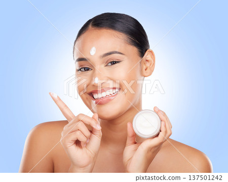 Portrait, happy woman and jar of cream in studio for aesthetic, skincare or advertising product on blue background. Model, beauty and moisturizer container of sunscreen, dermatology or face cosmetics 137501242