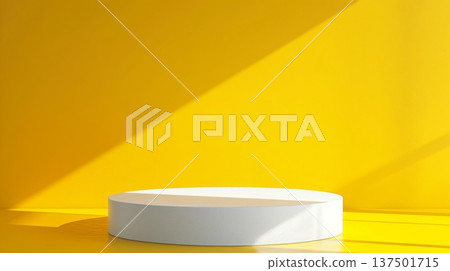 A white circular platform is set against a vibrant yellow background, illuminated by angled sunlight, creating strong shadows. 137501715