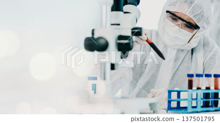 Science, blood sample and scientist in a hazmat suit doing research, experiment or study on dna. Pathology, professional and researcher working with rna vials for medical innovation in a laboratory. 137501795