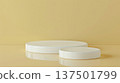 Two white round pedestals of different heights are placed on a matching yellow background surface and wall. 137501799
