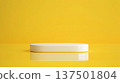 A minimalistic white platform placed on a reflective yellow surface with a solid yellow background in a studio setting. 137501804
