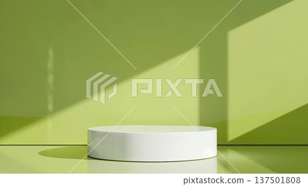 A round, white pedestal is set against a lime green backdrop. Sunlight casts diagonal shadows on the walls, creating a minimalist and modern aesthetic. 137501808