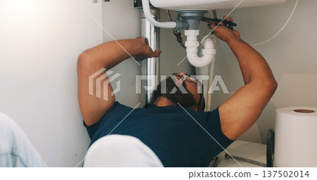 Plumber black man, kitchen and sink maintenance with tools, focus and pipe repair for drainage in home. Entrepreneur handyman, plumbing expert or small business owner in house for fixing water system 137502014