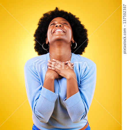Happy, excited and a young woman in studio with good news, hope and gratitude. Black person or winner on a yellow background for announcement, hands on chest and grateful for luck or self love 137502387