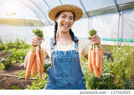 Greenhouse, portrait of happy woman holding carrots at sustainable small business in agriculture and natural organic food. Girl working at agro farm, vegetable growth in garden and eco friendly pride 137502685