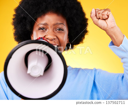 Black woman, portrait and megaphone with fist in protest, fight or march against a yellow studio background. African female person or activist with noise, bullhorn or loudspeaker in voice or justice Black woman, portrait and megaphone with fist in protest, fight or march against a yellow studio background. African female person or activist with noise, bullhorn or loudspeaker in voice or justice 137502711