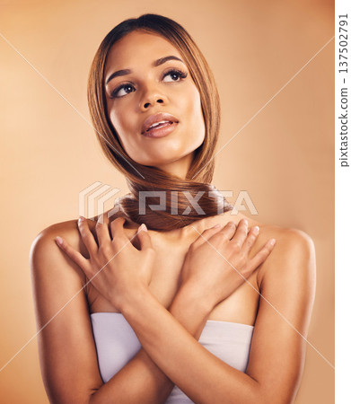 Care, woman and hair around neck for beauty isolated on brown background in studio. Thinking, long hairstyle and natural cosmetics of serious model in salon treatment for health, wellness or fashion Care, woman and hair around neck for beauty isolated on brown background in studio. Thinking, long hairstyle and natural cosmetics of serious model in salon treatment for health, wellness or fashion 137502791