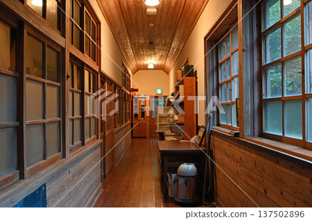 一棟復古的木製校舍走廊，柔和的燈泡照亮了走廊。 137502896