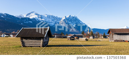 Traditional wooden hut in Bavarian countryside with snow capped Alps mountains and clear blue sky Traditional wooden hut in Bavarian countryside with snow capped Alps mountains and clear blue sky 137503368
