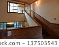 The stairwell of the wooden school building has warm wooden walls and soft lighting. 137503543
