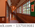 A nostalgic corridor in a wooden school building with warm wooden walls and wooden-framed windows 137503681