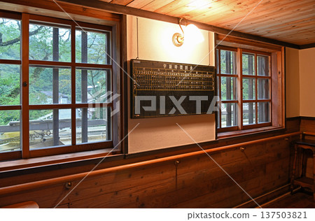 一扇燈光溫暖的窗戶旁，牆上掛著一塊復古的黑板，上面貼著課表。 137503821