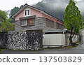 A rain-soaked wooden school building quietly stands in a mountain village shrouded in morning mist 137503829