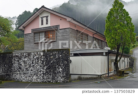 A rain-soaked wooden school building quietly stands in a mountain village shrouded in morning mist A rain-soaked wooden school building quietly stands in a mountain village shrouded in morning mist 137503829