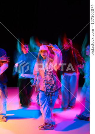 Young hip hop dancers performing under neon red and blue lights with motion blur Young hip hop dancers performing under neon red and blue lights with motion blur 137503874