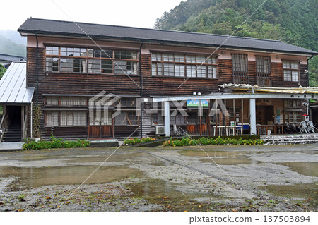 The charming clapboard exterior of the wooden school building, nestled in a quiet mountain village after the rain The charming clapboard exterior of the wooden school building, nestled in a quiet mountain village after the rain 137503894