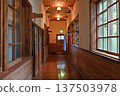 A long corridor in a wooden school building, with soft light reflecting off the polished wooden floors 137503978