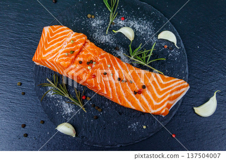 Raw salmon fillet with spices on black slate. Top view 137504007