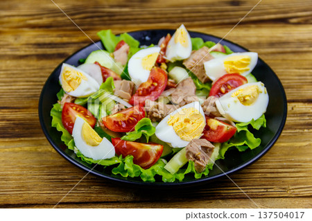 Tasty tuna salad with eggs, lettuce and fresh vegetables on wooden table Tasty tuna salad with eggs, lettuce and fresh vegetables on wooden table 137504017