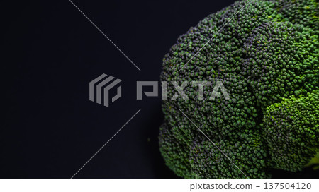 Broccoli floating on a black background Broccoli floating on a black background 137504120