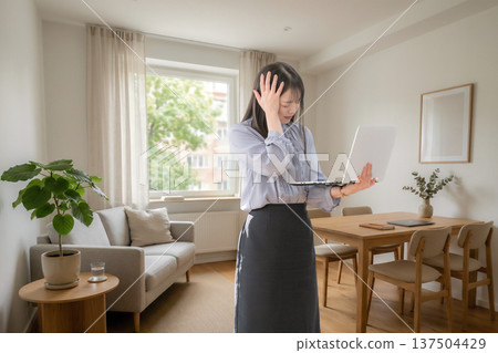 一位女士在家使用筆記型電腦時遇到困難。 137504429