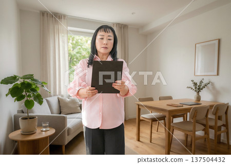 檢查平板電腦的女人 檢查平板電腦的女人 137504432
