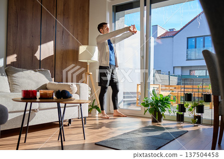 Man Stretching by Window in Living Room with Exercise Mat 137504458