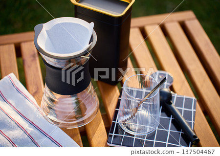 Pour over coffee brewing kit with dripper and glass on outdoor table Pour over coffee brewing kit with dripper and glass on outdoor table 137504467