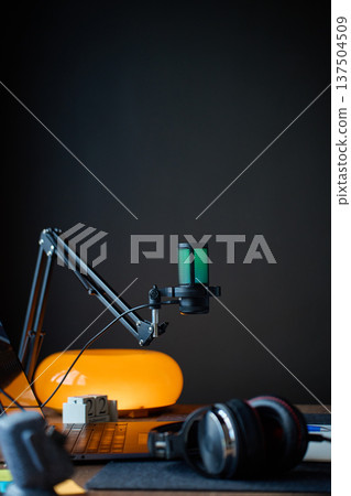 Podcast microphone, laptop and headphones in dark studio 137504509