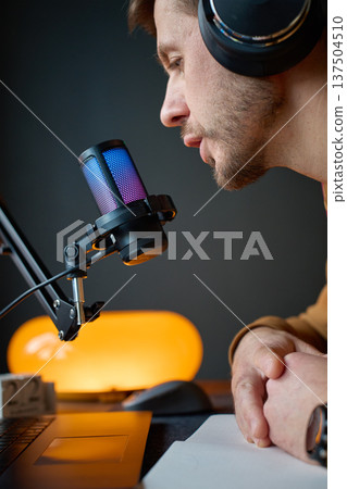 Podcast creator speaking into RGB microphone during streaming session Podcast creator speaking into RGB microphone during streaming session 137504510
