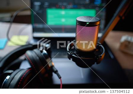 Microphone and headphones in front of laptop with audio editor software 137504512